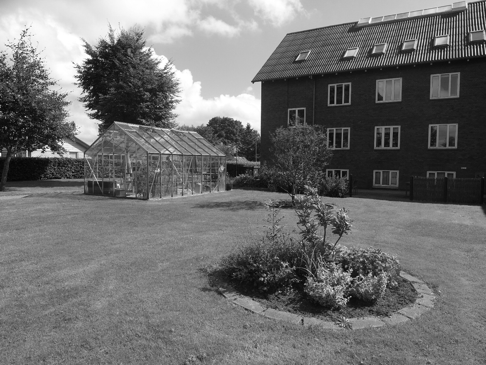Plejehjemmet Solgården har en velholdt have med drivhus og havebassin